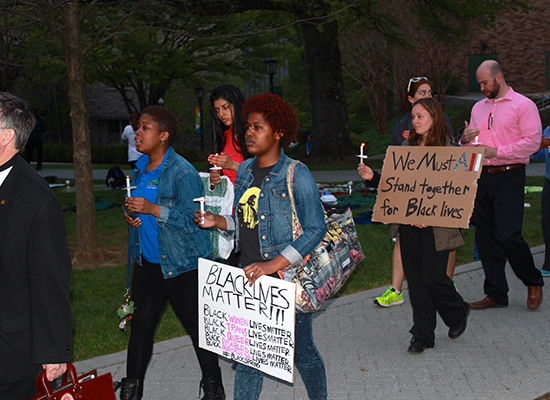 Students hold vigil candles and 