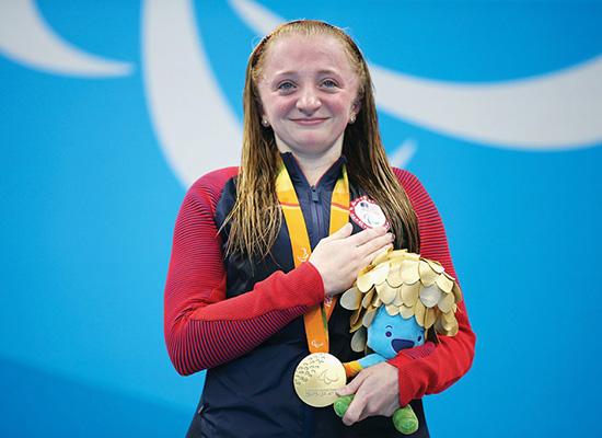 McKenzie Coan, ’18, celebrates on the podium at the medal ceremony for the women’s 50-meter freestyle.