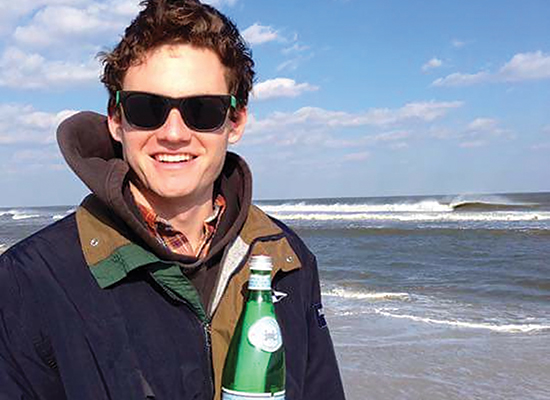 Tommy Zanowic with bottle, standing at the shore.