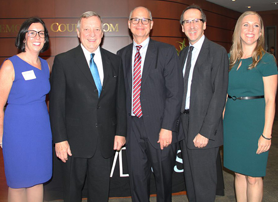 Katie Vannucci standing with Sen. Dick Durbin D-Ill. and interim dean Michael Kaufman.