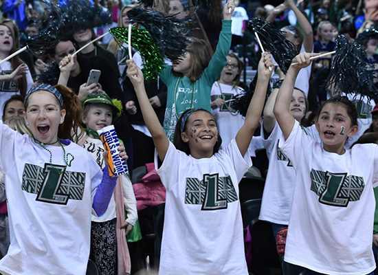 Girls wearing Loyola t-shirts cheer amongst audience.