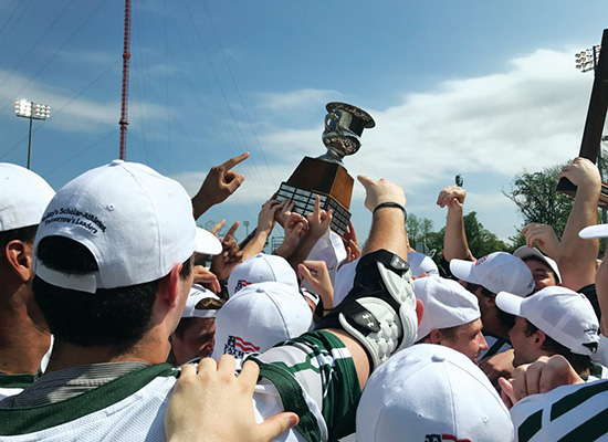 Loyola athletes gather in cheer and lift their trophy.