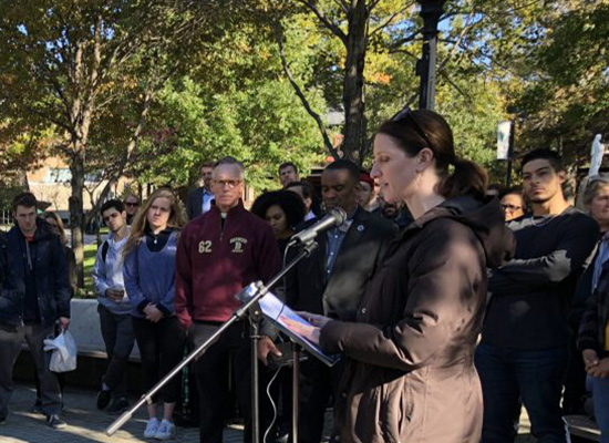 Beth Steiner stand amongst crowd of people in the quad, offering words during the vigil.