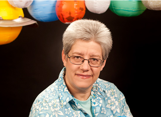 Inge Heyer photo portrait with air-filled planetary models above her.