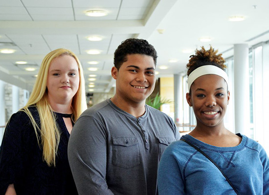 Photo of three students standing side-by-side.