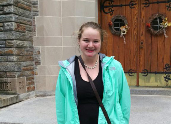 Photo of Caitlin in front of alumni chapel entrance.