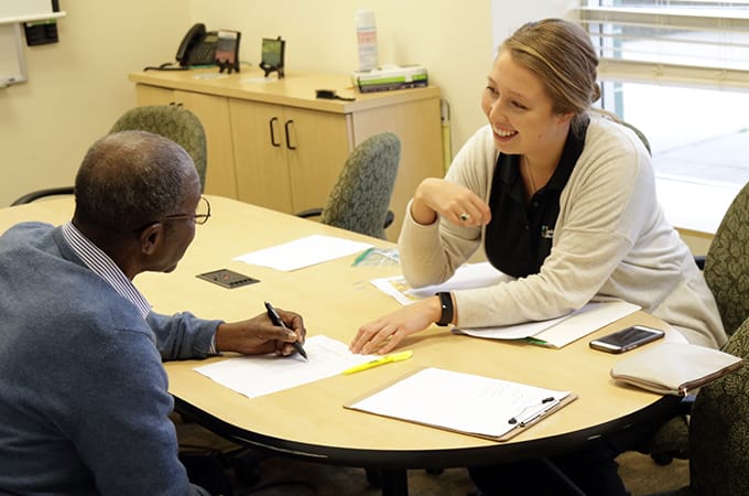 Loyola Clinical Center assistant helping a patient fill out paperwork