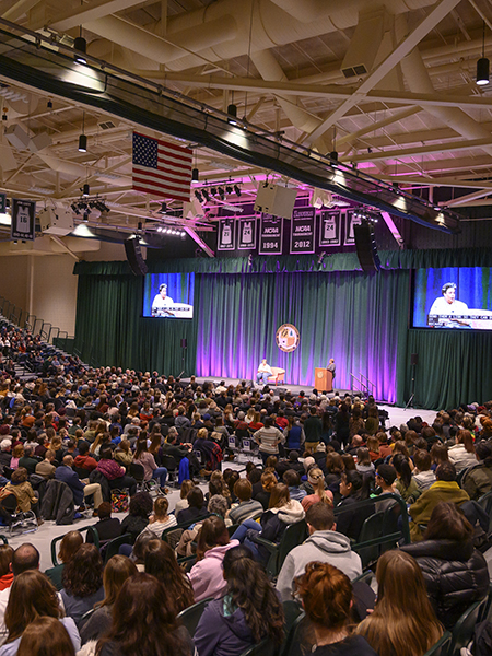 Roxane Gay on stage with large crowd seated on the bleachers.