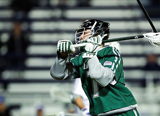 Pat Spencer runs in full lacrosse gear wearing the renowned Loyola green.