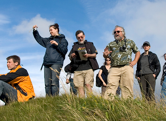 Kelly Devries and others standing atop a green grassy hill