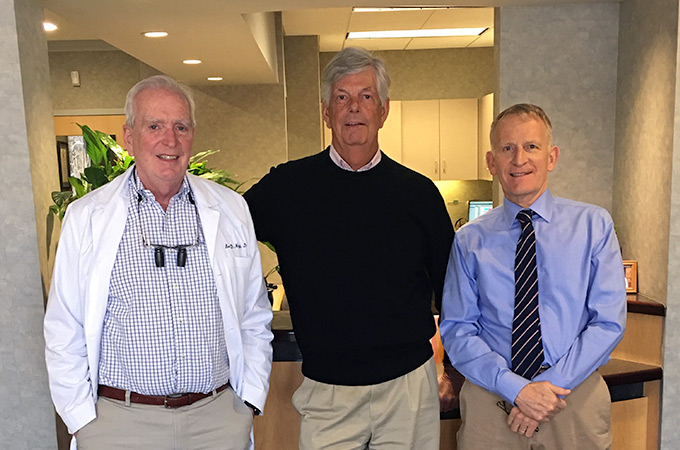 Doctors Barry, Jim, and Lew pose together by the office's front desk.