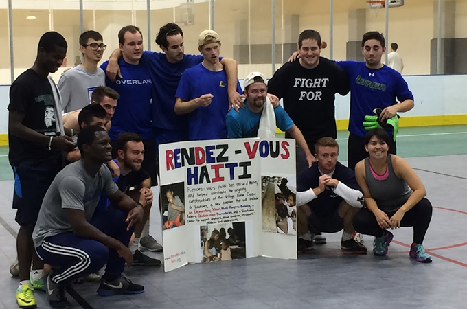 Loyola students and Haitian locals gather to pose for photo for soccer tournament.