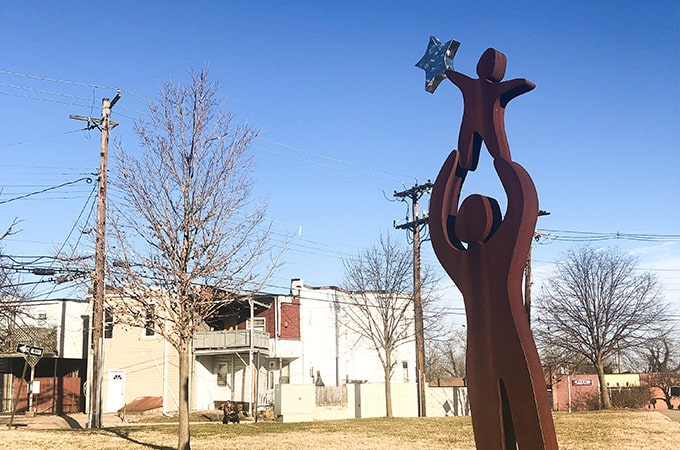 Statue of a child being raised up by an adult