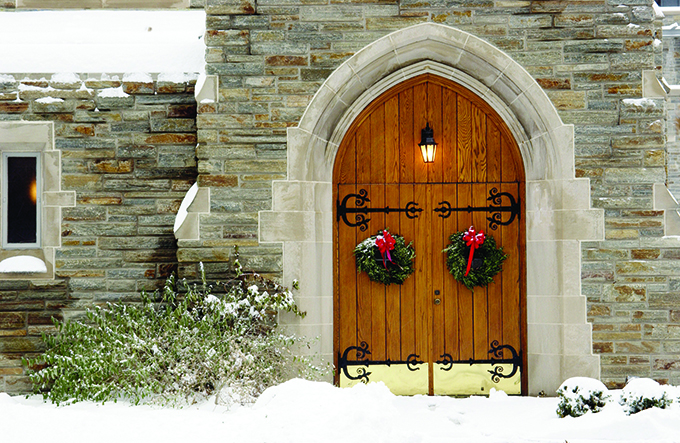 Front door of the Alumni Memorial Chapel in the snow decorated for Christmas