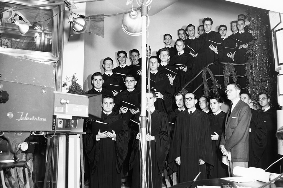 Loyola choir posing in front of a television camera for the 1953 Christmas concert