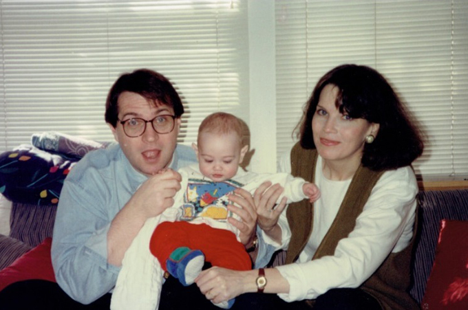 Joe and Gayla sitting on the couch with their new child.