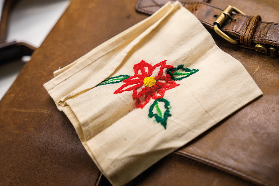 Close up photo of a handkerchief with an embroidered flower design