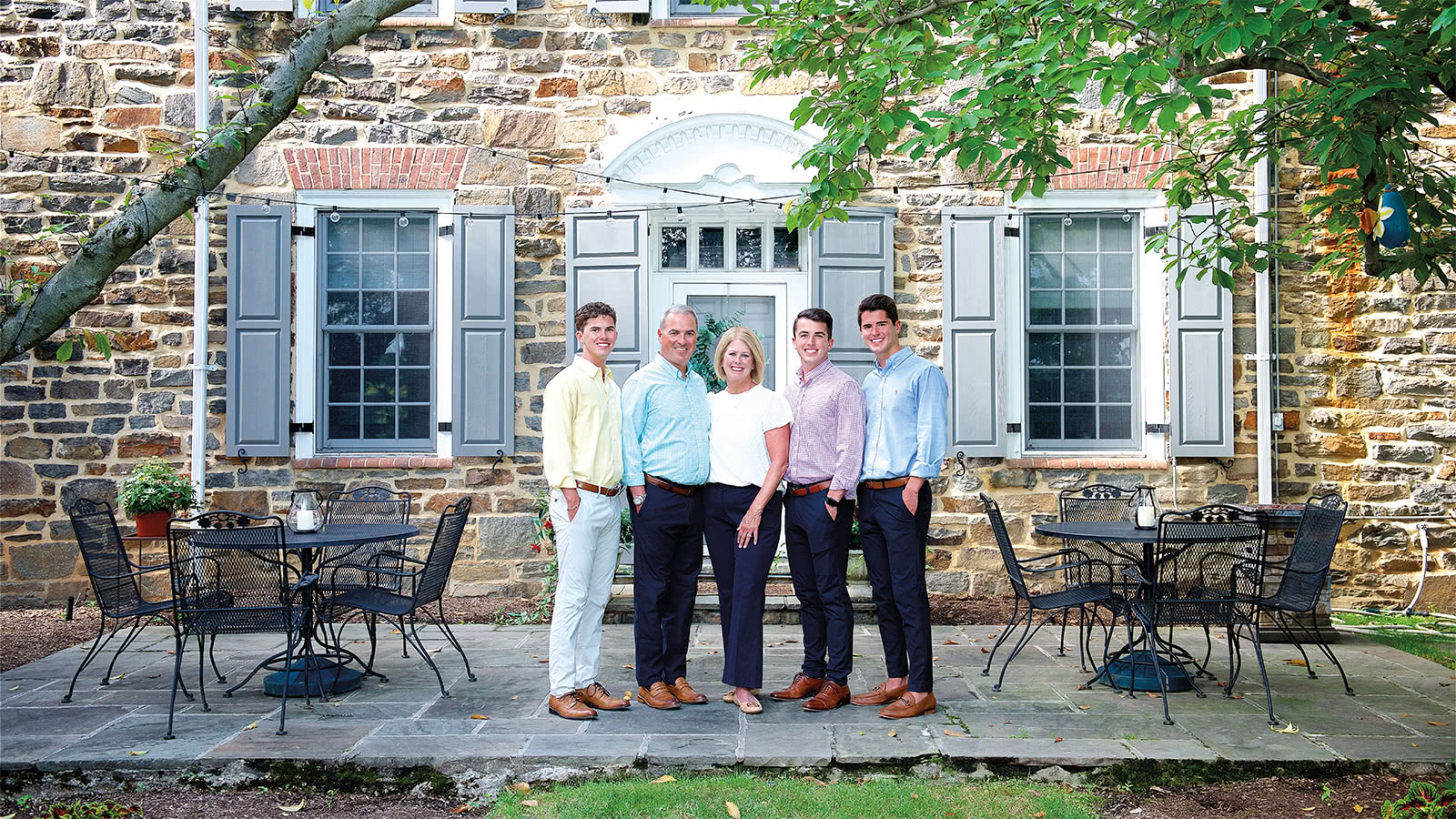 The Sawyer family posing for a group photo in front of the Arminger House on a sunny day