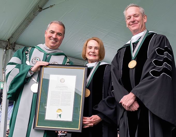 Nick and Susie Simon pose with Terry Sawyer holding a framed document