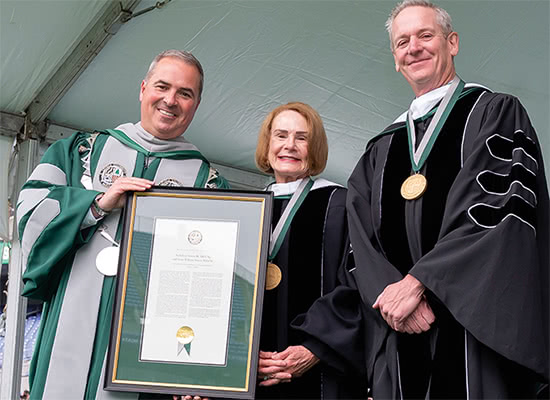 Nick and Susie Simon pose with Terry Sawyer holding a framed document