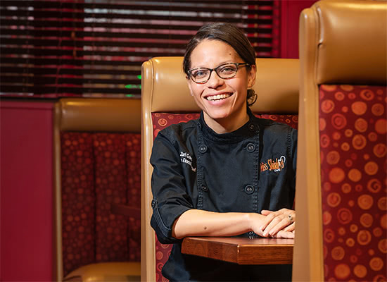 Zuri Coles sits in a booth in the restaurant Miss Shirley's Cafe while posing for a photo