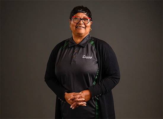 Diane Parker poses for a photo while wearing her Loyola Dining uniform