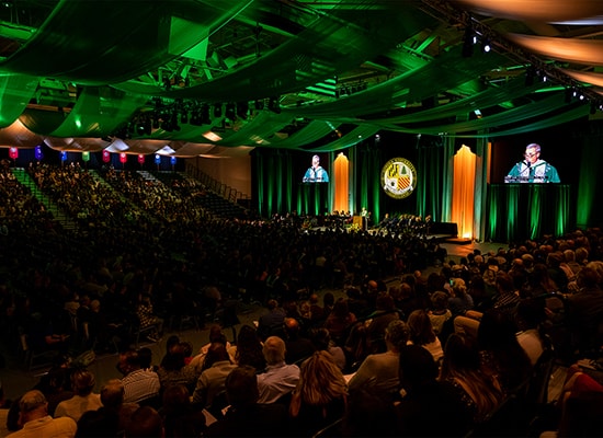 A large group gathered at Reitz Arena listens to President Terry Sawyer's inauguration speech