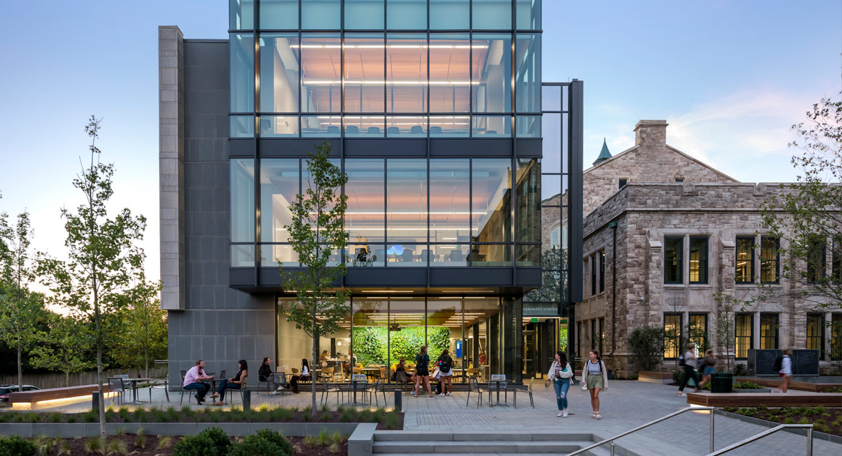 Students walk in front of the Fernandez Center at dusk