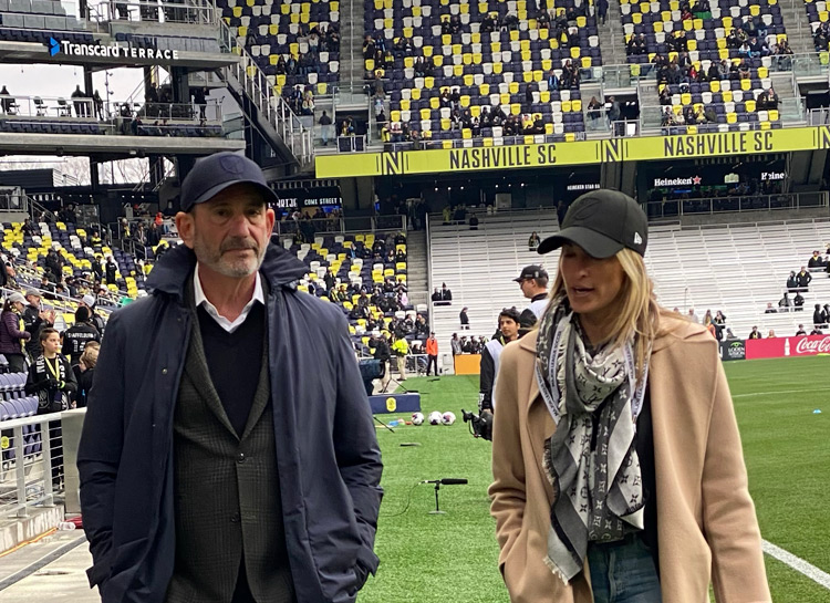 Nina Tinari walking and talking in a soccer stadium