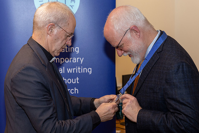 Frederick Bauerschmid receiving a medal from a priest