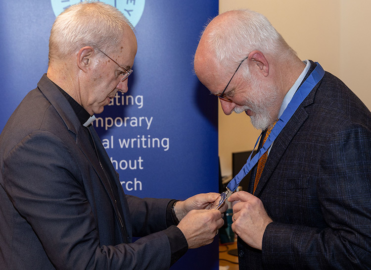 Frederick Bauerschmidt receiving a medal from a priest