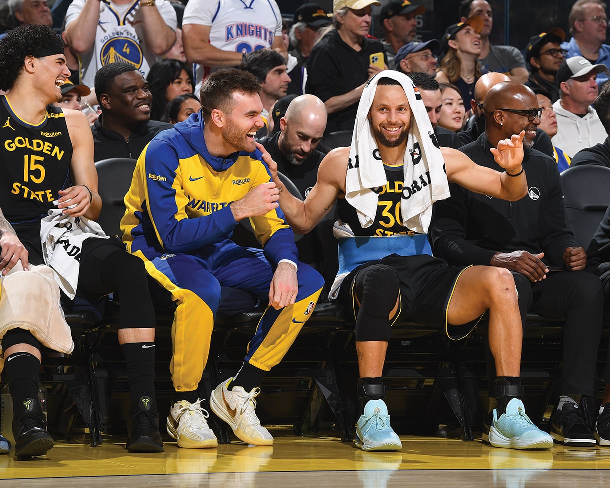 Pat Spencer, ’19 sitting next to Steph Curry