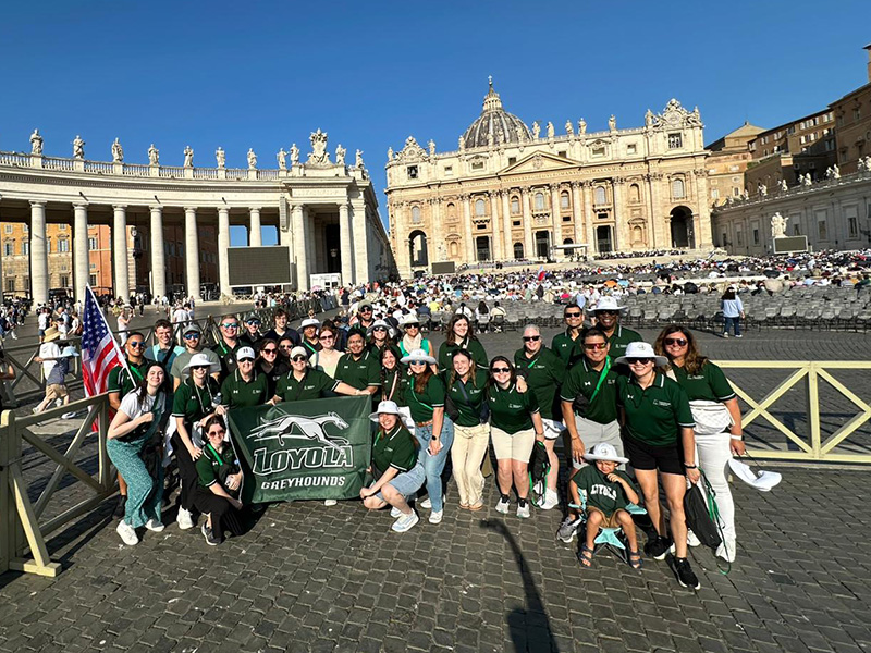 A large group of Loyola Students posing in the Vatican courtyard