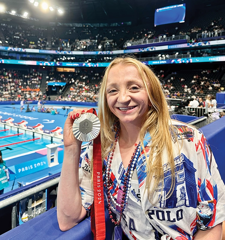 McKenzie Coan, ’18, holds her silver medal at the 2024 Paris Paralympic Games.