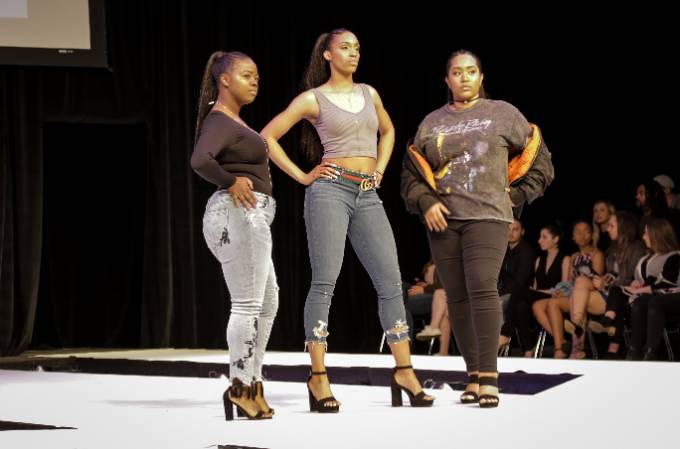 three models posing on stage at a fashion show
