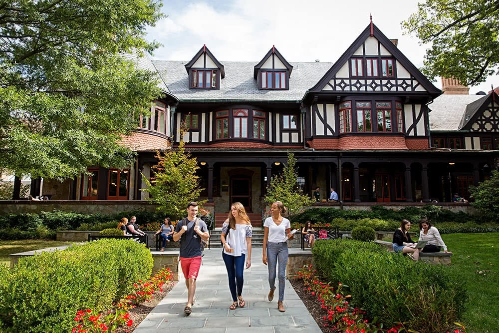 Students sitting and walking in front of the Humanities Building