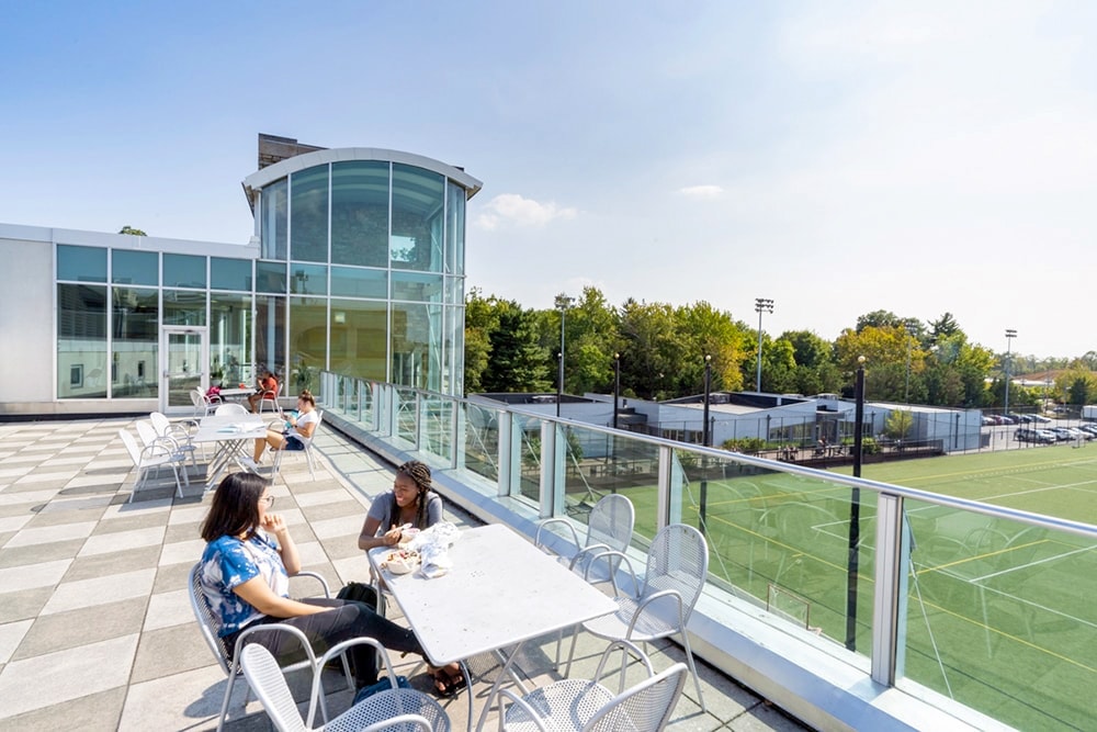 Students sitting at tables and conversing near the Modular Buildings