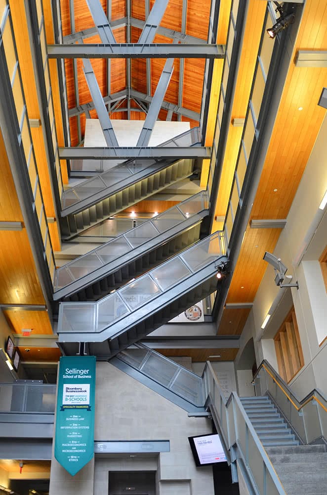 The towering interior of the Sellinger Building, with golden wood and metal staircases