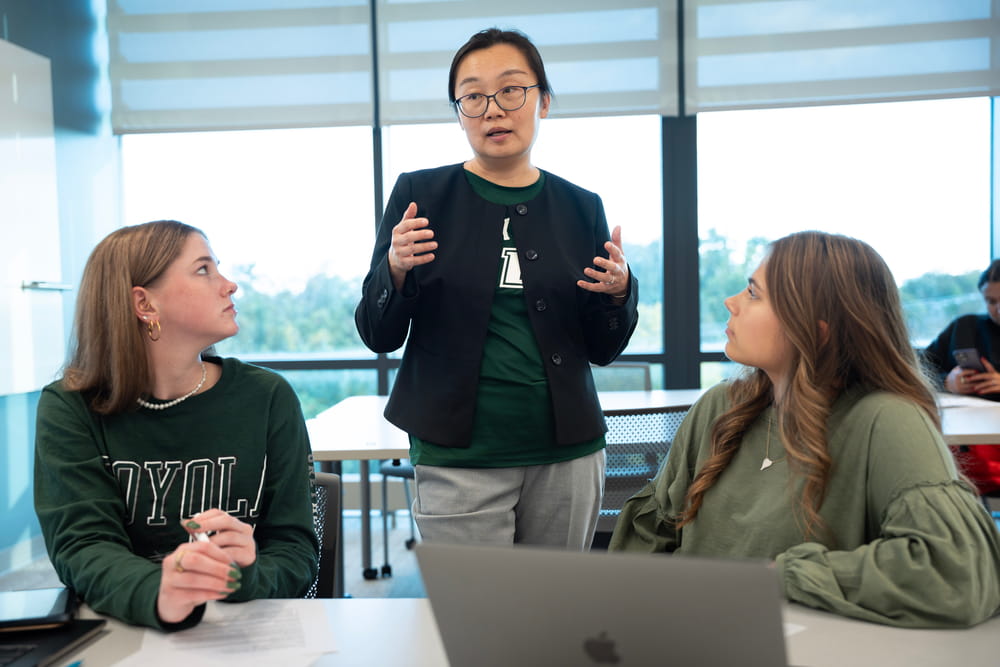 A professor explains a concept to two students.