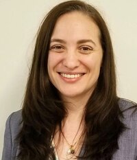 Dr. Loren Henderson smiles at the camera wearing a grey blouse