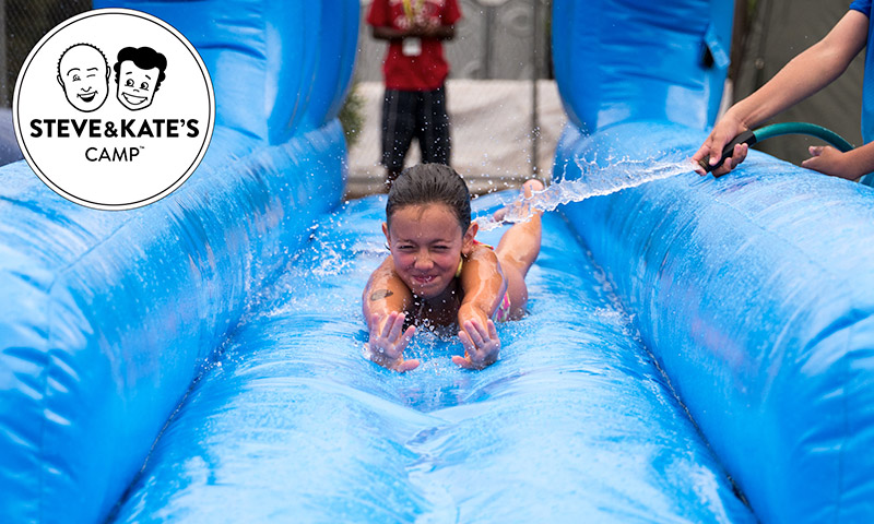 A young girl sliding on a water slide head first