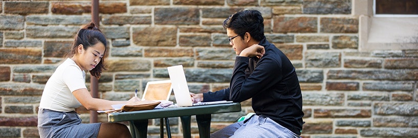 Students reading near bookcase