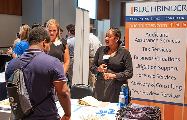 A student talking to a recruiter at a career fair