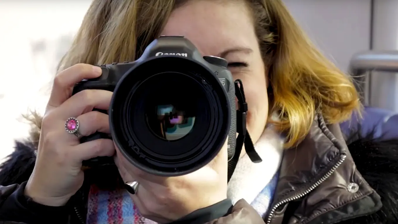 A woman holding a camera - Press enter to play