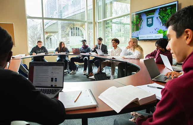Students sitting around a circular desk having a discussion