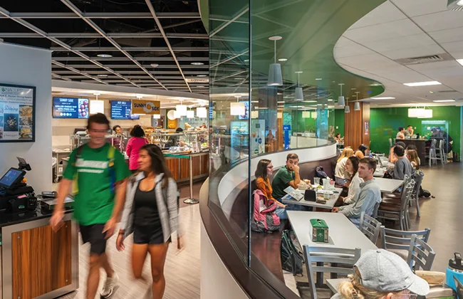 Students walking and eating in Loyola's Boulder 2.0 dining facilitiy
