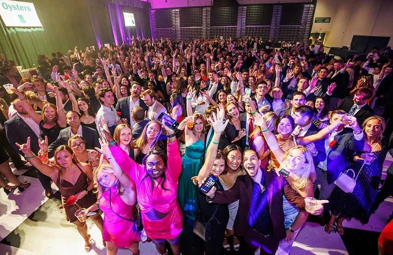 A crowd of students dressed in formal clothing and cheering