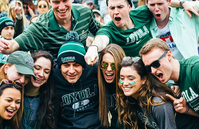 Students wearing Loyola gear cheer during an athletic event