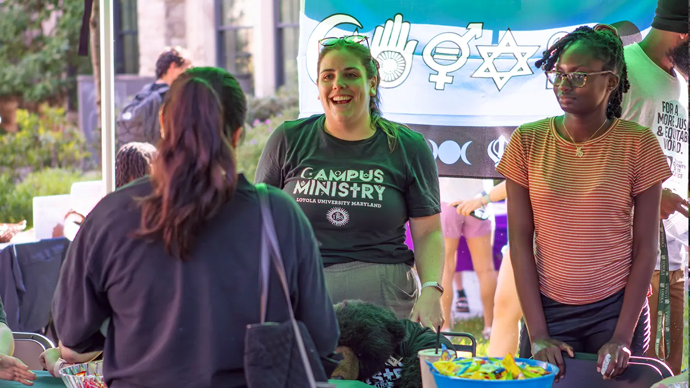 Students talk at a booth during the student activity fair - Press enter to play