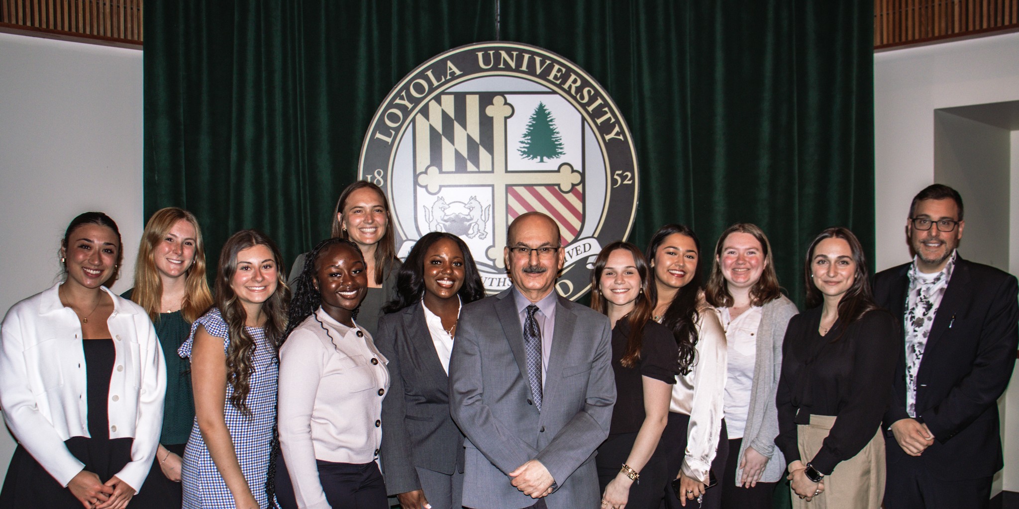 group of students with Loyola seal at the back